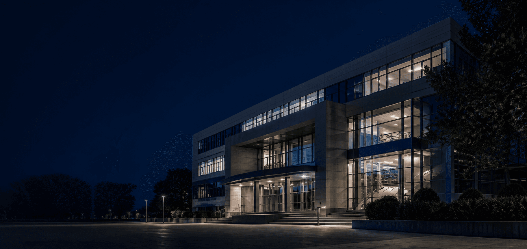 Clădire universitară modernă, iluminată seara